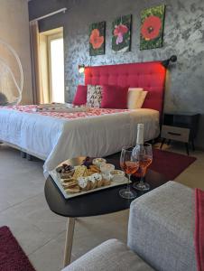 a hotel room with a tray of food and glasses of wine at Sea Holly Gozo in Nadur