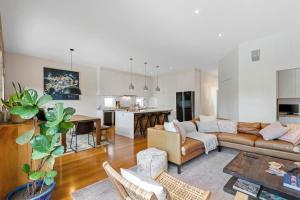 a living room with a couch and a table at Sophisticated 2-Bed House with a Pool in Seddon