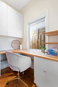 eine Küche mit einem Schreibtisch, einem Stuhl und einem Fenster in der Unterkunft Sophisticated 2-Bed House with a Pool in Seddon