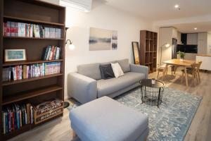 een woonkamer met een bank en een boekenplank bij Modern 2-Bed Apartment in Melbourne's Heart in Melbourne