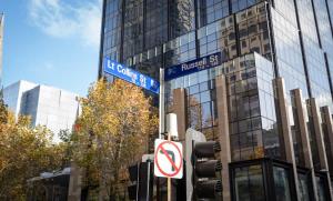 a street sign and a traffic light in front of a building at Modern 2-Bed Apartment in Melbourne's Heart in Melbourne