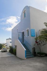 a white house with a staircase leading up to it at Atrium Villa in Fira