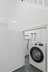 メルボルンにあるSleek 2-Bed Terrace near Local Parksの白いバスルーム(洗濯機、乾燥機付)