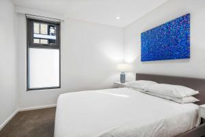 Habitación blanca con cama y ventana en Southbank Central 2-Bed - Pool, Gym & City Views, en Melbourne
