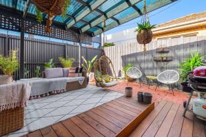 a patio with a couch and chairs on a deck at Refined 2-Bed House with a Charming Courtyard in Melbourne