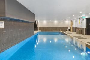 ein großer blauer Pool in einem Gebäude in der Unterkunft Unbeatable 2-Bed Apartment In City Centre in Melbourne