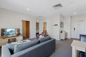 sala de estar con sofá y TV en Unbeatable 2-Bed Apartment In City Centre en Melbourne