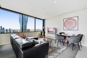 a living room with a couch and a table at Chic Central Pad with City Views, Pool and Gym in Melbourne