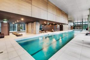 a large swimming pool with blue water in a building at Chic Central Pad with City Views, Pool and Gym in Melbourne