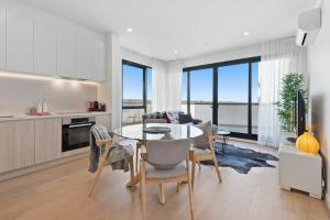 a kitchen and living room with a table and chairs at Stylish and Convenient Two Bedroom Apartment in Burwood