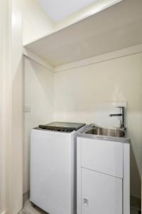 a small kitchen with a sink and a stove at Modern 2-bed St Kilda Apartment Near Shops in Melbourne