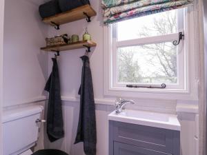 baño con lavabo y ventana en Bumble's Retreat en Whepstead