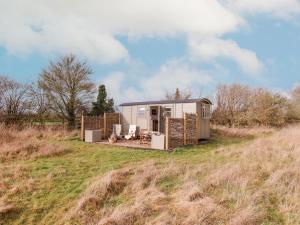 a tiny house in a field on a hill at Bumble's Retreat in Whepstead