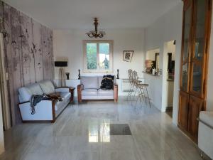 ein Wohnzimmer mit einem Sofa und einem Stuhl in der Unterkunft Bastide gecko doré in Cotignac