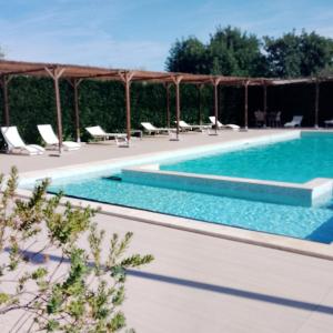 a swimming pool with chaise lounge chairs next to a swimming pool at Tre Balate Natura e Relax in Modica
