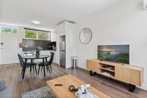 ein Wohnzimmer mit einem Esstisch und einer Küche in der Unterkunft Polished 1-Bed St Kilda Pad in Prime Location in Melbourne