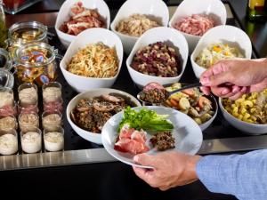 um buffet cheio de tigelas de diferentes tipos de alimentos em Hotel Campanile Besançon Nord Ecole Valentin em Besançon