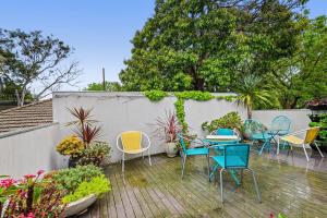 d'une terrasse avec des chaises, une table et une clôture. dans l'établissement Spacious 2-Bed Apartment Minutes From Elwood Beach, à Melbourne