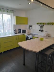 uma cozinha com armários amarelos e uma mesa em Ferienhaus Judit em Alsóörs
