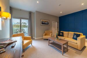 sala de estar con muebles amarillos y pared azul en The Ro Hotel Windermere, en Bowness-on-Windermere