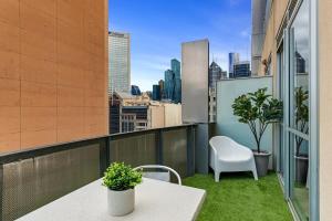 a balcony with a table and a chair on a building at Sophisticated CBD 2-Bed Apartment by Yarra River in Melbourne