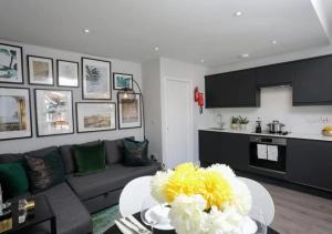 uma sala de estar com um sofá e uma mesa com flores em Aisiki Apartments at Stanhope Road, North Finchley, Multiple 2 or 3 Bedroom Pet Friendly Duplex Flats, King or Twin Beds with Aircon & FREE WIFI em Finchley