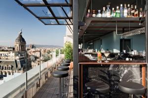 a bar on the roof of a building with a view at NH Collection Barcelona Gran Hotel Calderon in Barcelona