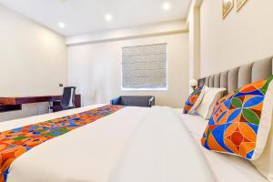 a bedroom with a large bed and a window at FabHotel Pravaasam Residency in Jaipur