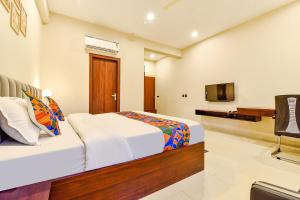 a hotel room with a bed and a television at FabHotel Pravaasam Residency in Jaipur