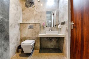 a bathroom with a toilet and a sink and a mirror at FabHotel Pravaasam Residency in Jaipur