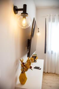 Un escritorio blanco con una lámpara y un jarrón. en A Casa Das Letras, en Cangas de Morrazo