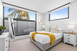 een slaapkamer met een bed en een groot raam bij Impeccably Chic 3-Bed House by Fawkner Park in Melbourne