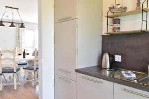 eine Küche mit weißen Schränken und einem Waschbecken in der Unterkunft Meeresmelodie in Olpenitz