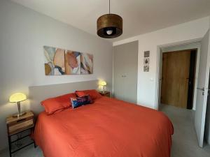a bedroom with a large orange bed with two pillows at CANIGOU in Port-Vendres