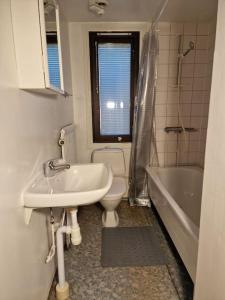 łazienka z umywalką, toaletą i wanną w obiekcie Lugn och skön lägenhet centralt. w Göteborgu