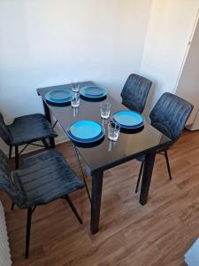 stół z 4 krzesłami i niebieskimi płytami w obiekcie Lugn och skön lägenhet centralt. w Göteborgu