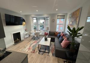 ein Wohnzimmer mit Sofa und Tisch in der Unterkunft Aisiki Apartments at Stanhope Road, North Finchley, Airconditioned Multiple 2 or 3-Bedroom, Pet Friendly Duplex Flats, King or Twin Beds with Free Wi-Fi in Finchley