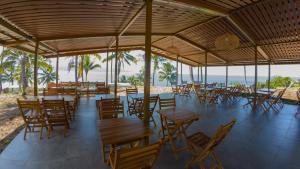 a restaurant with tables and chairs on the beach at Bobocabin Bunaken Hills, Manado in Manado