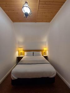 ein Schlafzimmer mit einem großen Bett mit zwei Nachttischen in der Unterkunft The Black Cat in Bran