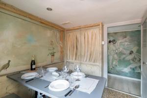 a table with plates and a bottle of wine at Attic San Marco for 5 Person - AC - Wifi in Venice