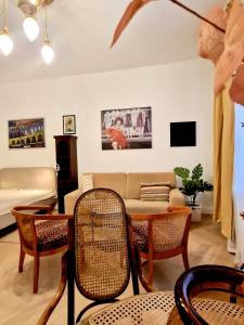 ein Wohnzimmer mit einem Sofa, einem Tisch und Stühlen in der Unterkunft Charming Apartman in Budapest