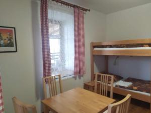 a dining room with a table and a bunk bed at Ekofarma Bílý mrak in Borohrádek