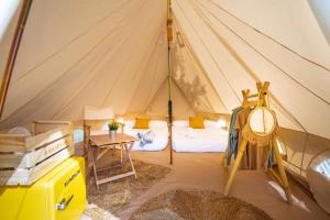 ラーヴラにあるKampaoh Praia de Angeirasのテント付きの客室で、ベッド1台とテーブルが備わります。