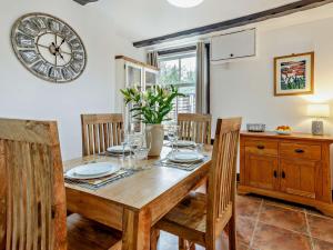 a dining room with a table and a clock on the wall at 2 Bed in Oswestry 76537 in Gobowen