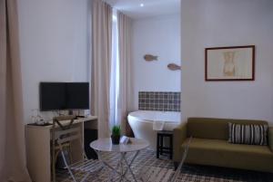 バレンシアにあるホテル サン ロレンツォ ブティックのリビングルーム(ソファ、テレビ、バスタブ付)