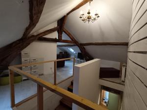 an attic room with a staircase and a chandelier at Tournan en Brie, centre ville, superbe appartement in Tournan-en-Brie