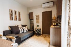 a living room with a couch and a kitchen at Lef Apartment in Thessaloniki