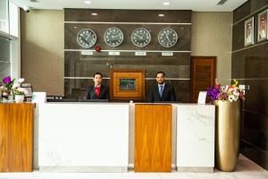 two men in suits sitting at a reception desk at Ginger Luxury House in Juffair