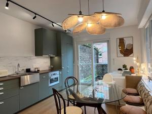 une cuisine et une salle à manger avec une table en verre dans l'établissement Havre des Anges - Pont de Fragnée, Guillemins, à Liège