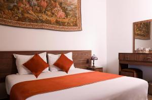 a bedroom with a bed with a painting on the wall at L'auberge des Emirs in Dayr al Qamar